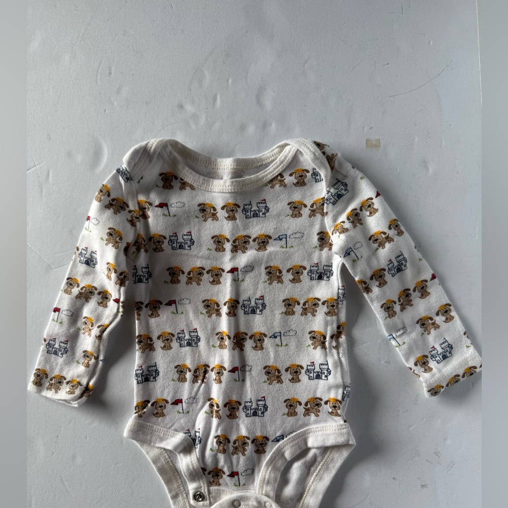 White long sleeve onesie with dogs and castles on it